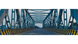 Blick auf eine lange Brücke, die sich in der Ferne bis zum Horizont erstreckt. Der Betrachter steht am Anfang der Brücke und schaut in die Weite, wobei die Struktur der Brücke deutlich sichtbar ist und den Weg bis zum Ende führt.