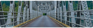 Blick auf das Ende einer Stahlbrücke, aufgenommen vom Anfang der Brücke, mit der Struktur des Stahlrahmens deutlich sichtbar.